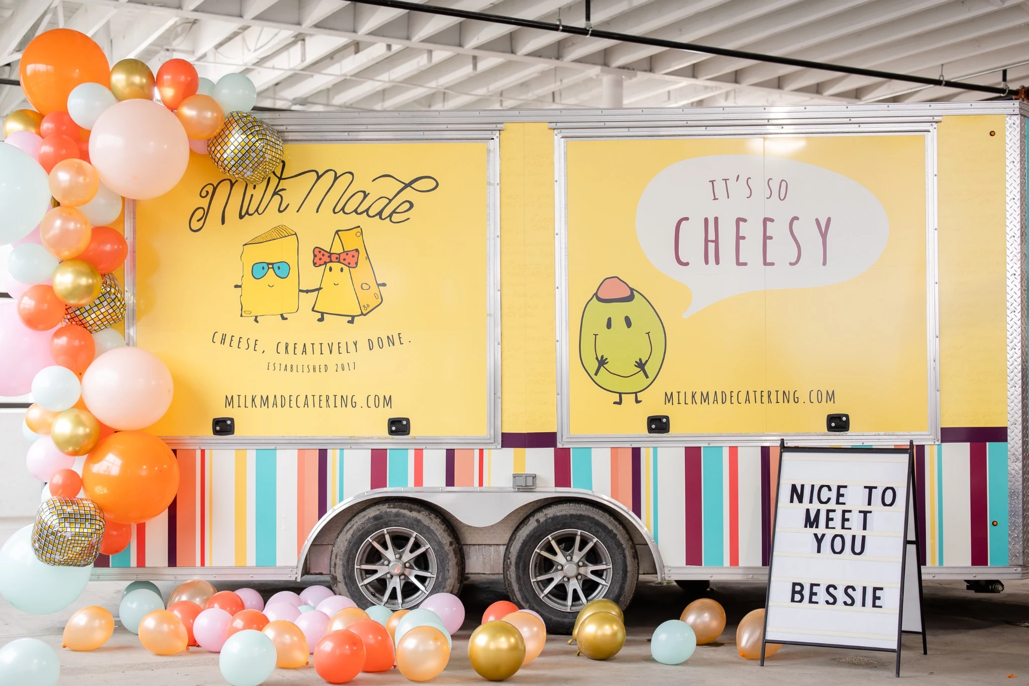 Milk Made’s Bessie trailer with illustrated cheese characters and colorful event decorations